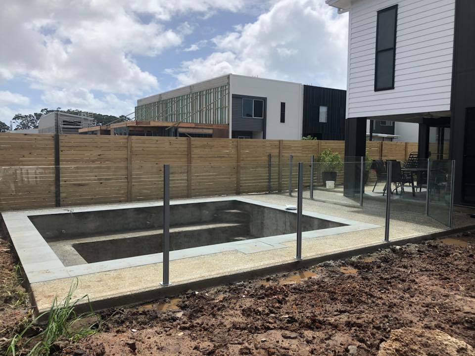 Semi-frameless glass pool fence with upright posts between panels